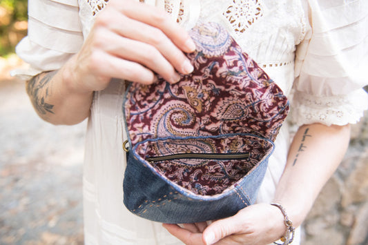 Person holding a patterned fabric pouch outdoors