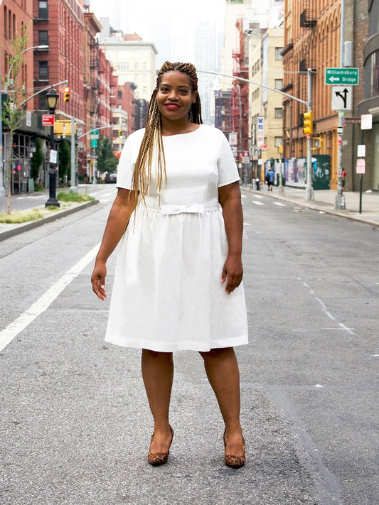 Woman in a white dress standing on an urban street