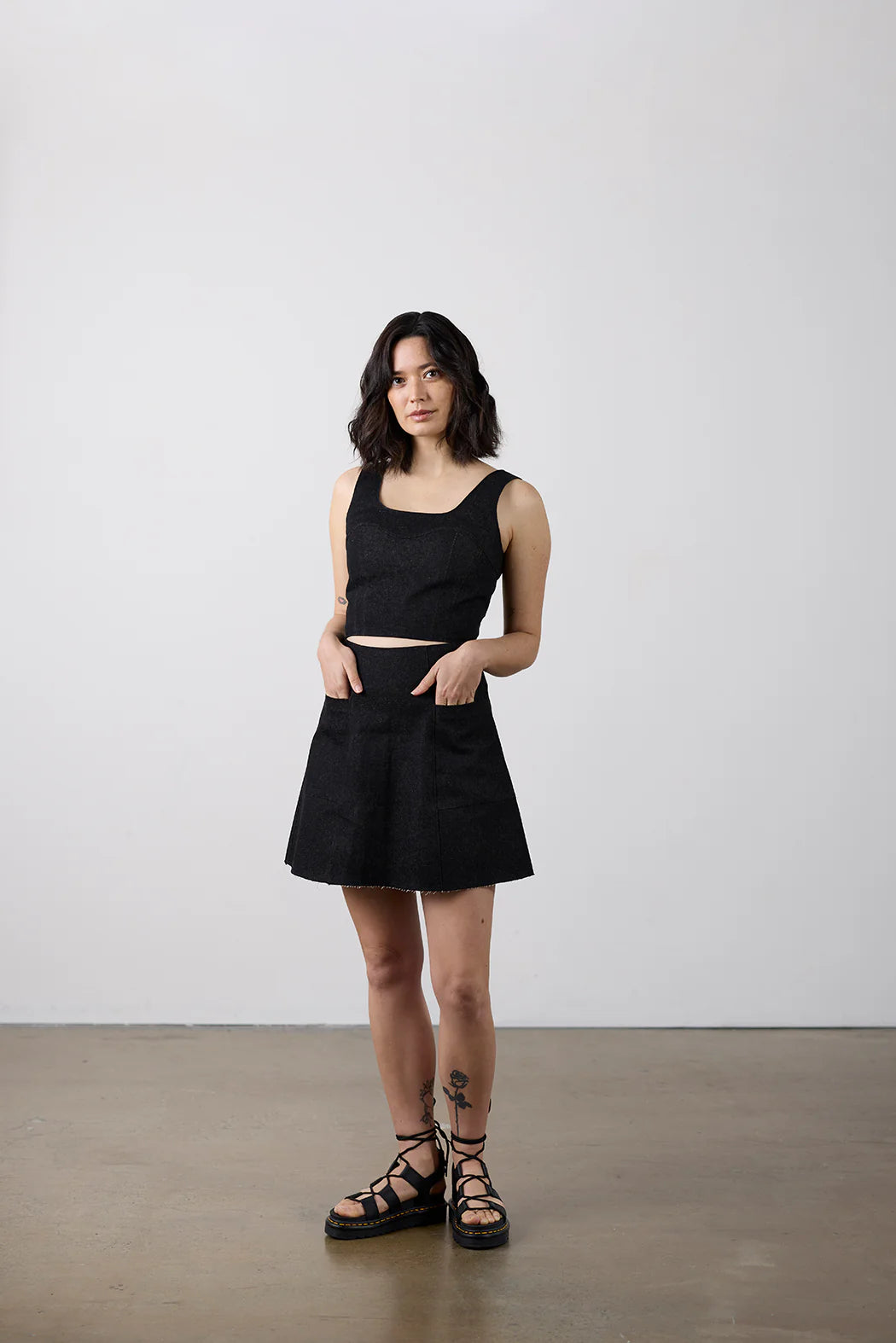 Woman wearing a black dress standing against a white background