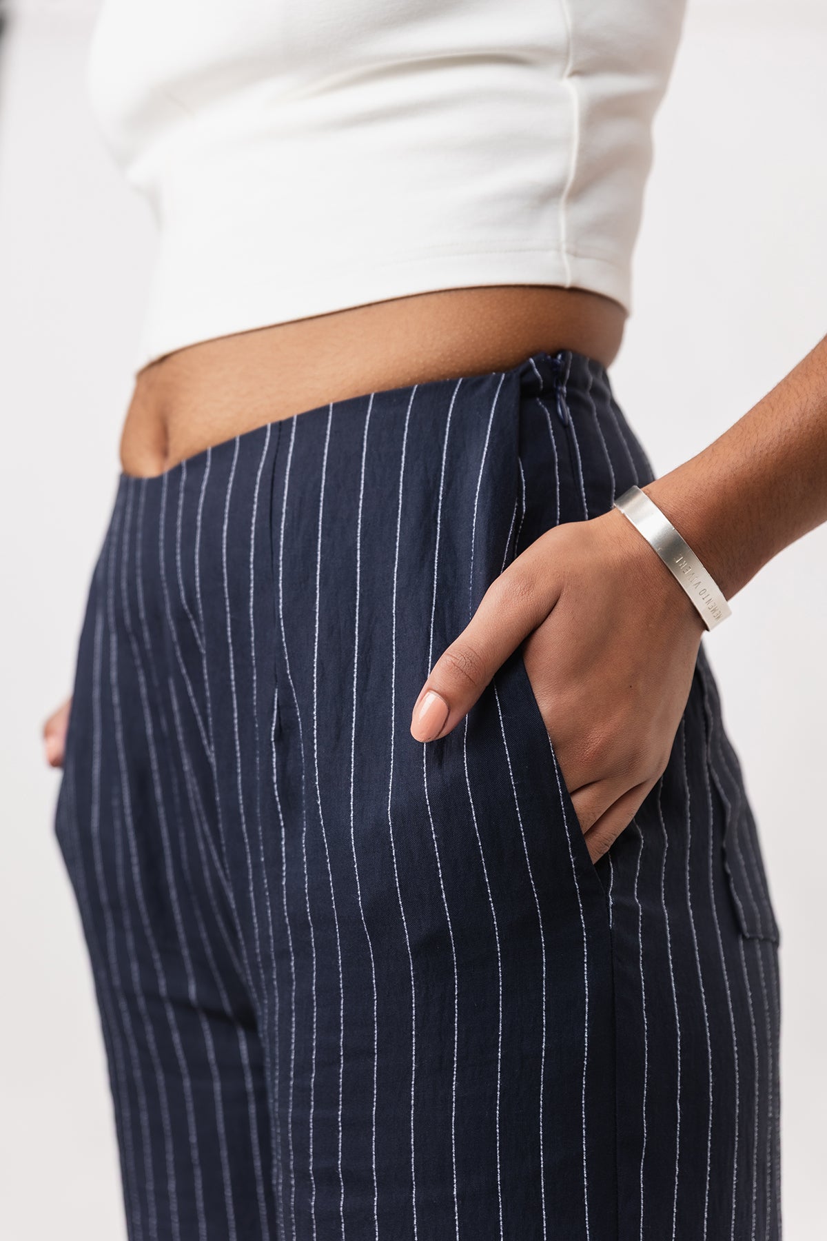 Navy pinstripe pants worn by a person on a light background