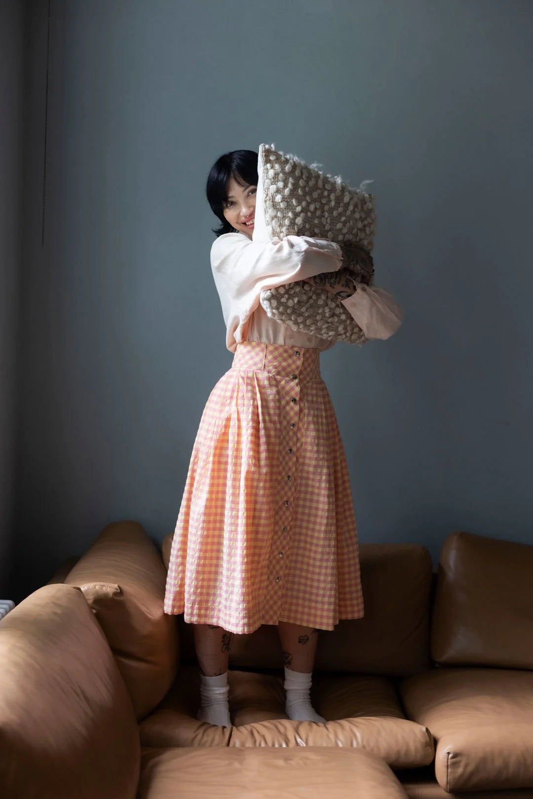 Woman holding a decorative pillow in a living room setting
