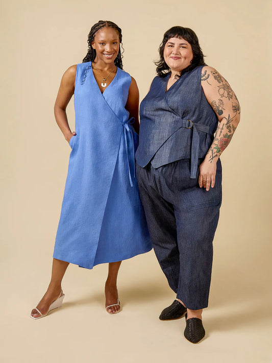 Two women wearing blue sleeveless tops and pants on a beige background