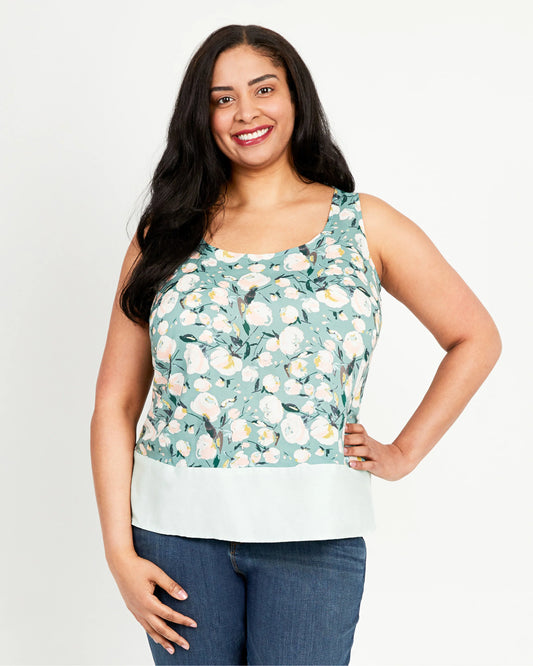 Woman wearing a floral sleeveless top with a plain background