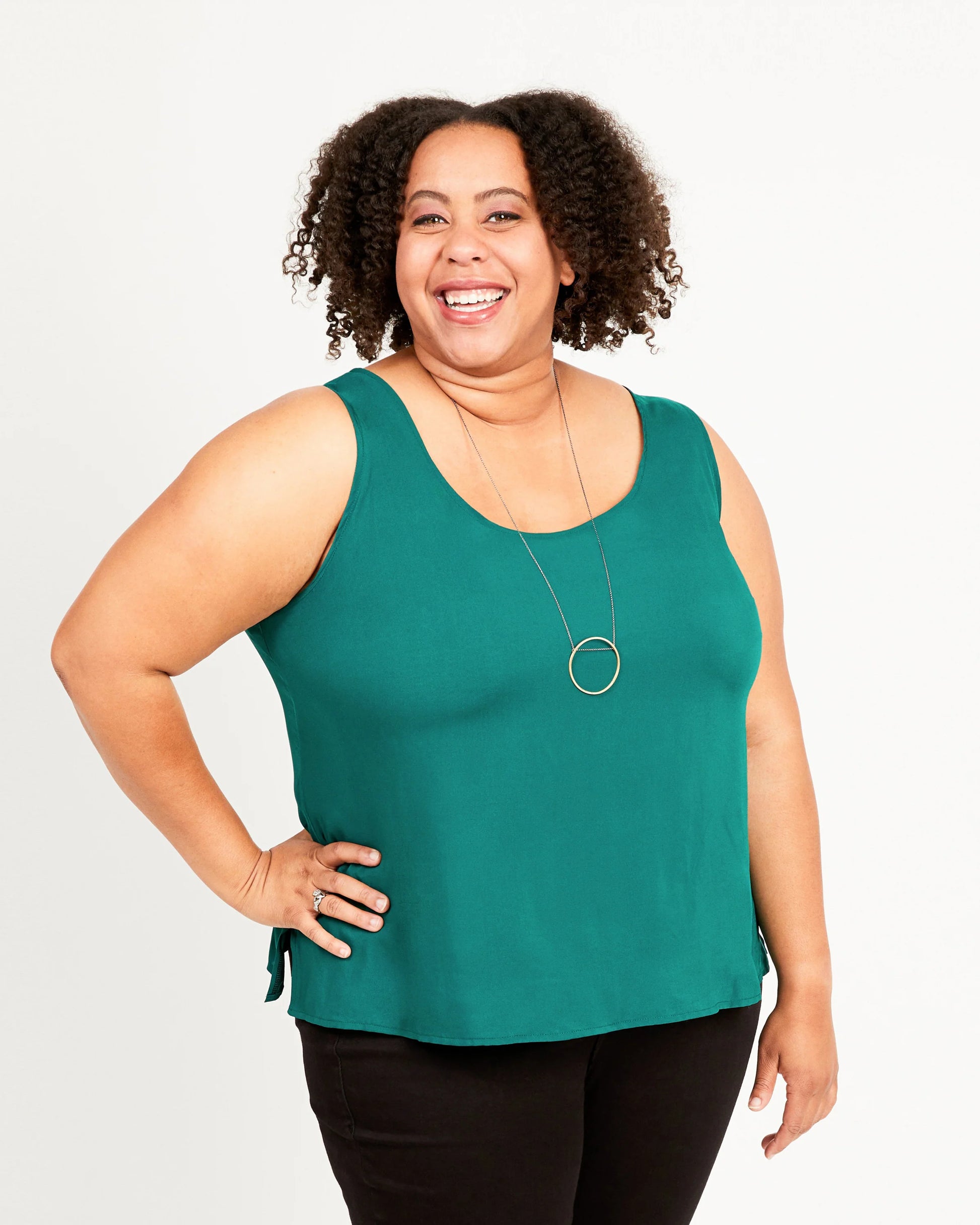 Woman wearing a green sleeveless top against a white background
