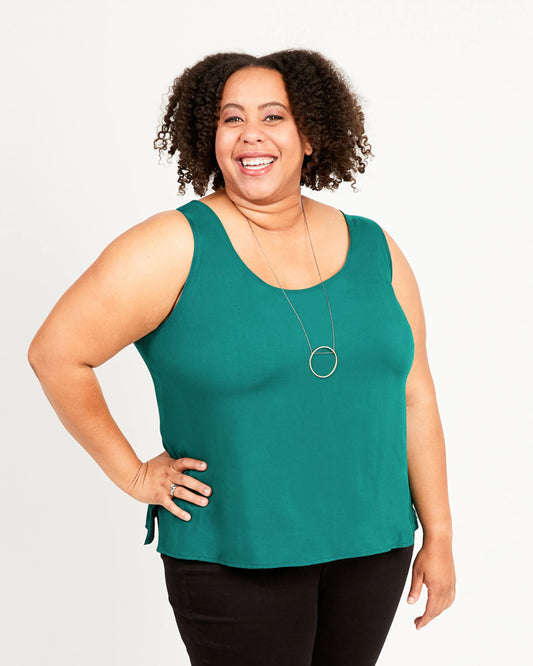 Woman wearing a green sleeveless top against a white background