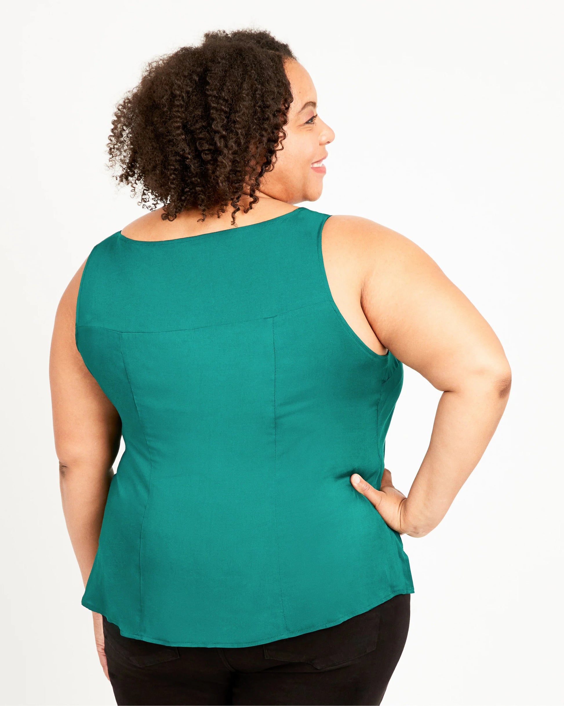 Woman wearing a green sleeveless top on a white background