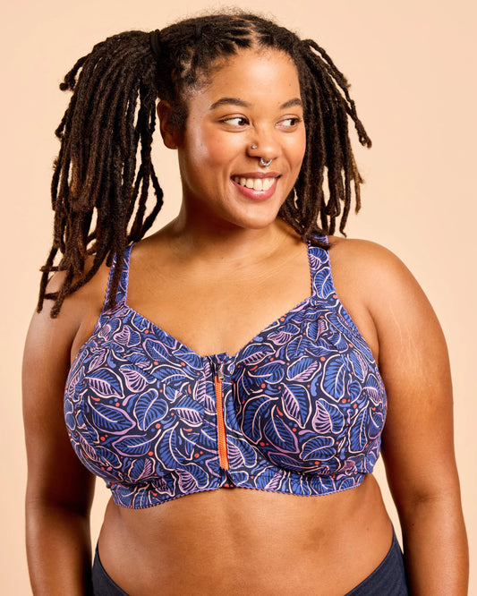 Woman wearing a blue patterned bikini top against a beige background