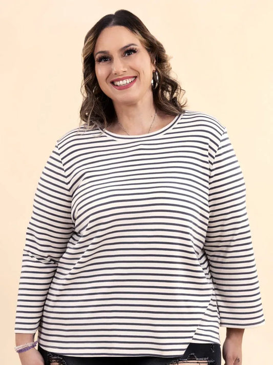 Woman wearing a black and white striped shirt against a beige background