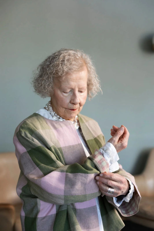 Woman holding a small wrapped gift in a home setting