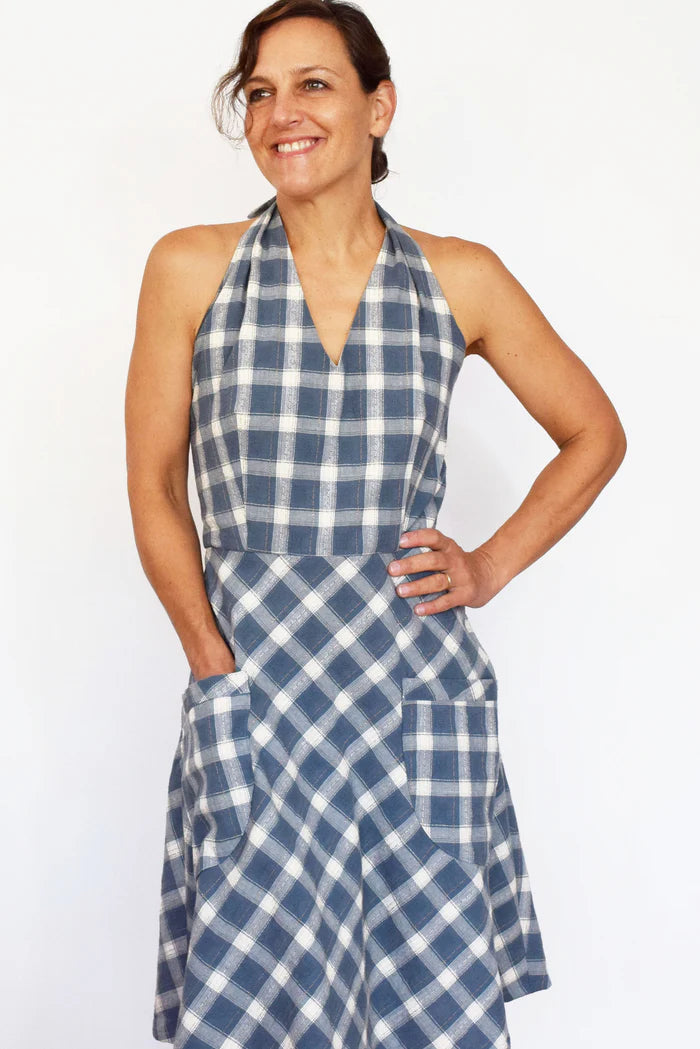 Woman wearing a blue and white checkered dress against a white background