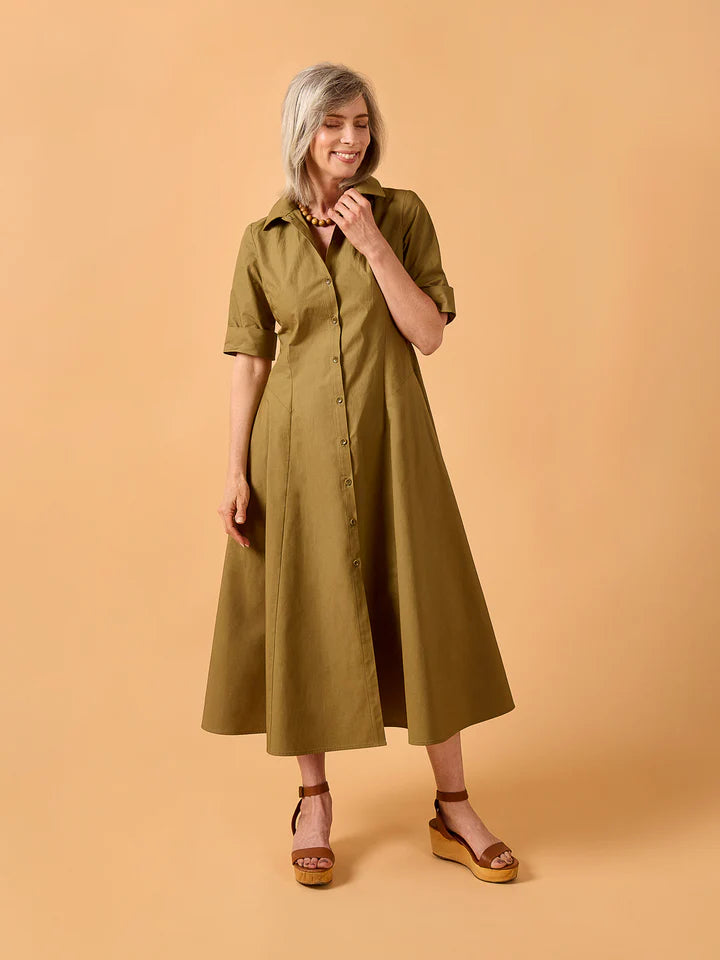 Woman wearing a green dress against a beige background