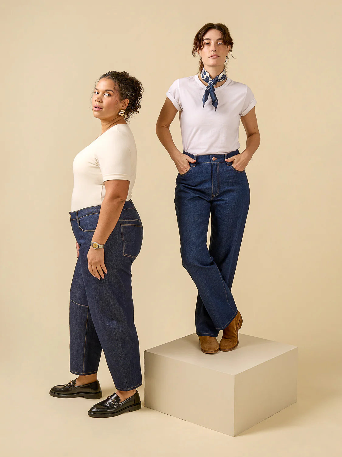 Two people wearing white shirts and blue jeans on a beige background
