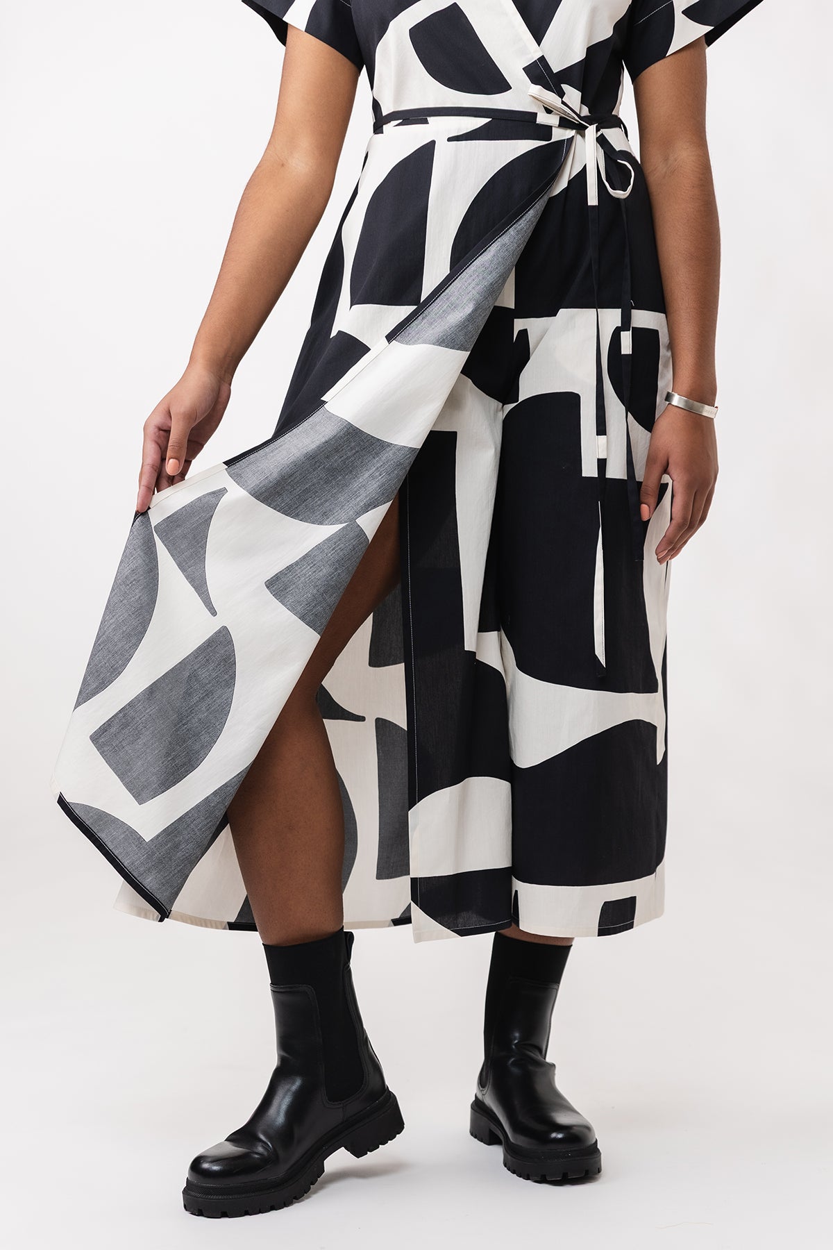 Person wearing a black and white patterned dress on a white background