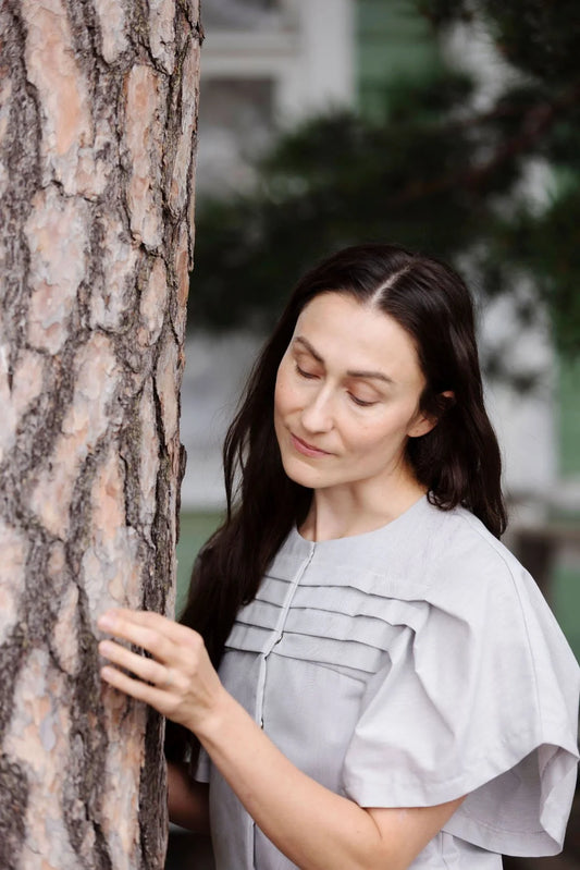 Woman hugging a tree with a blurred outdoor background