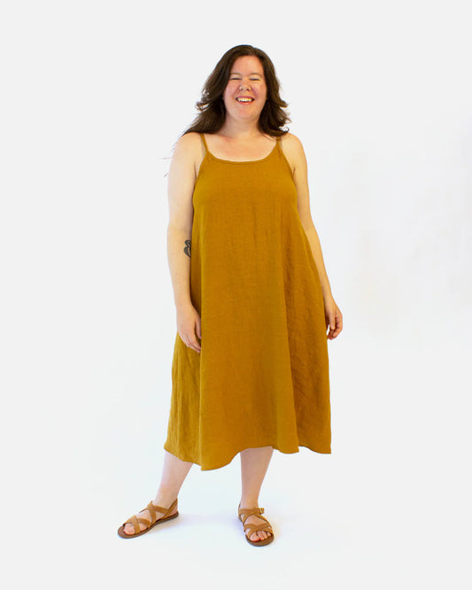 Woman wearing a mustard yellow dress on a white background