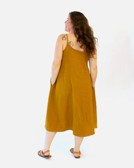 Woman wearing a mustard yellow dress against a white background