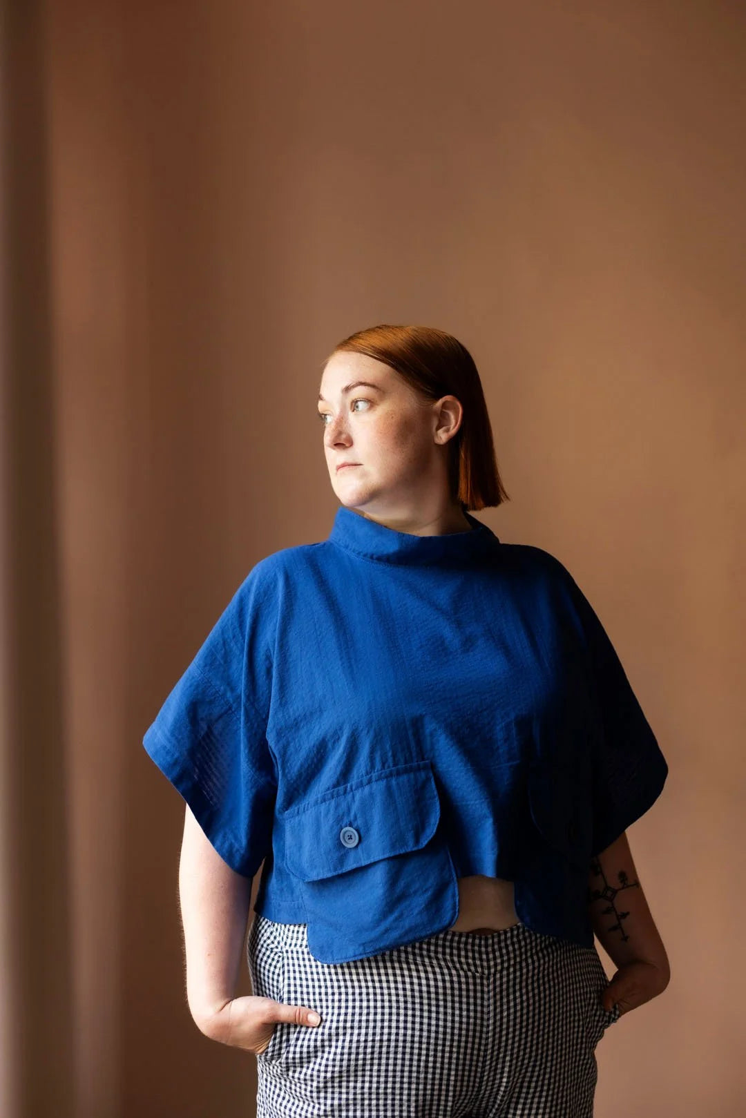 Person wearing a blue top against a brown background