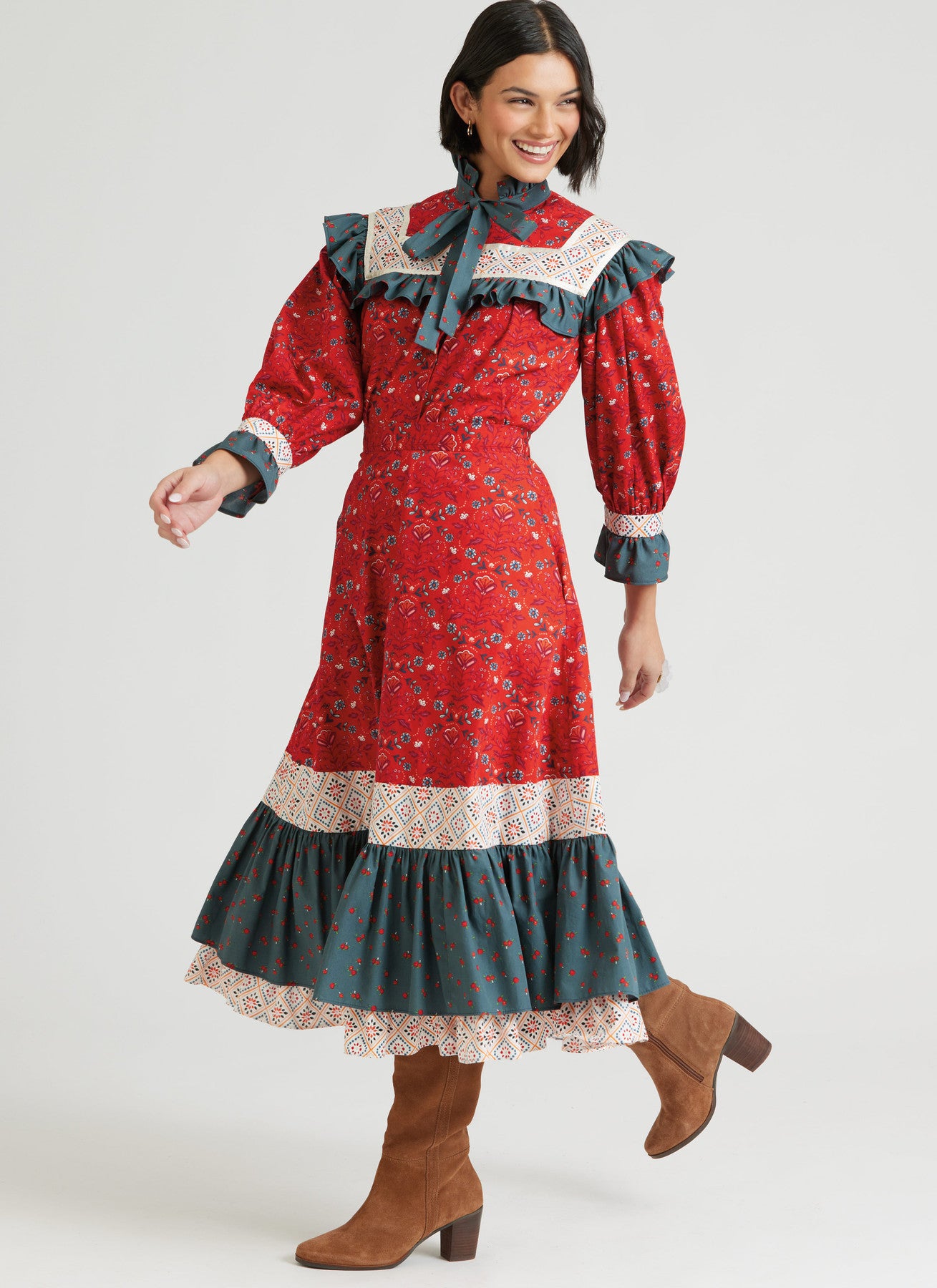 Woman wearing a red and green dress with lace details on a white background