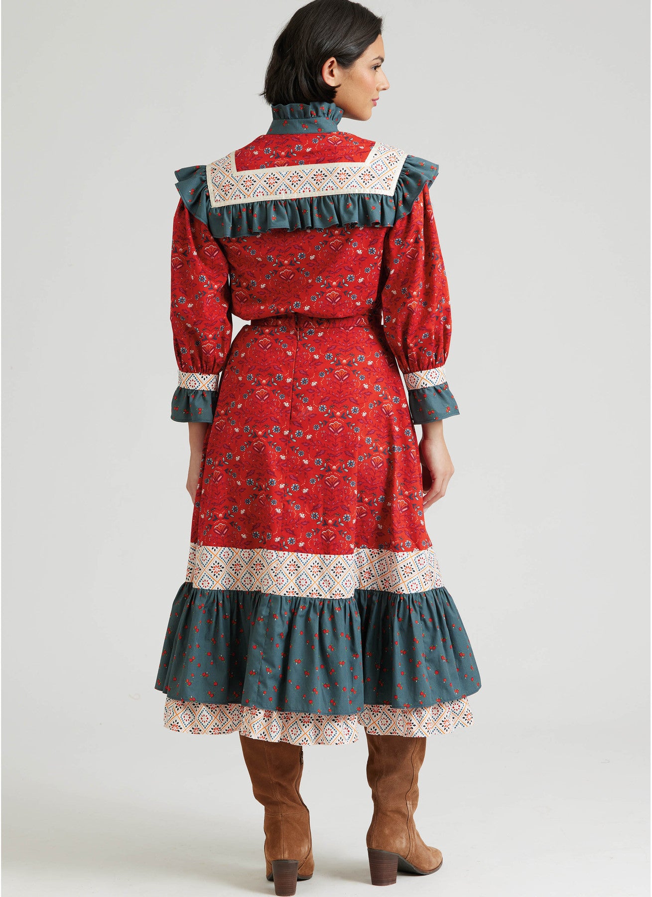 Woman wearing a red and blue dress with lace details on a white background