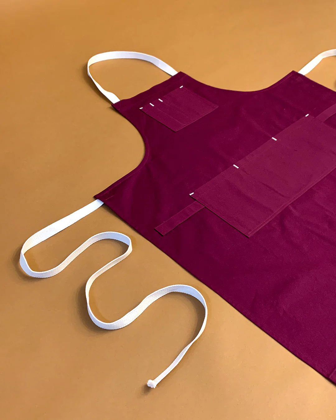 Purple apron with white straps on a brown background