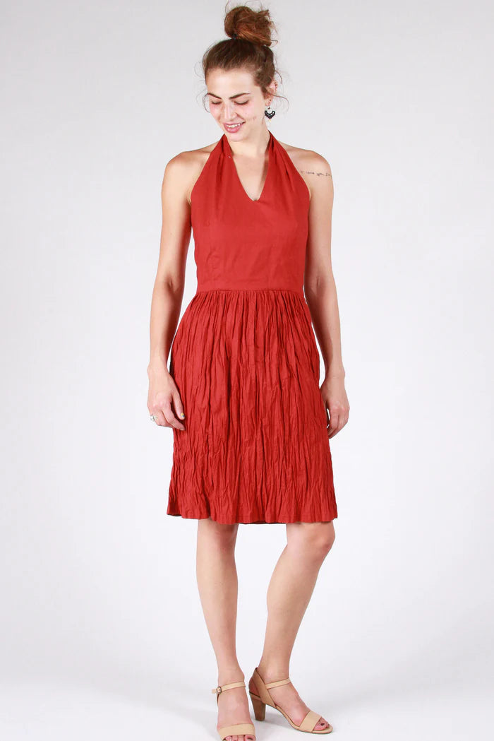 Woman wearing a red halter dress on a white background