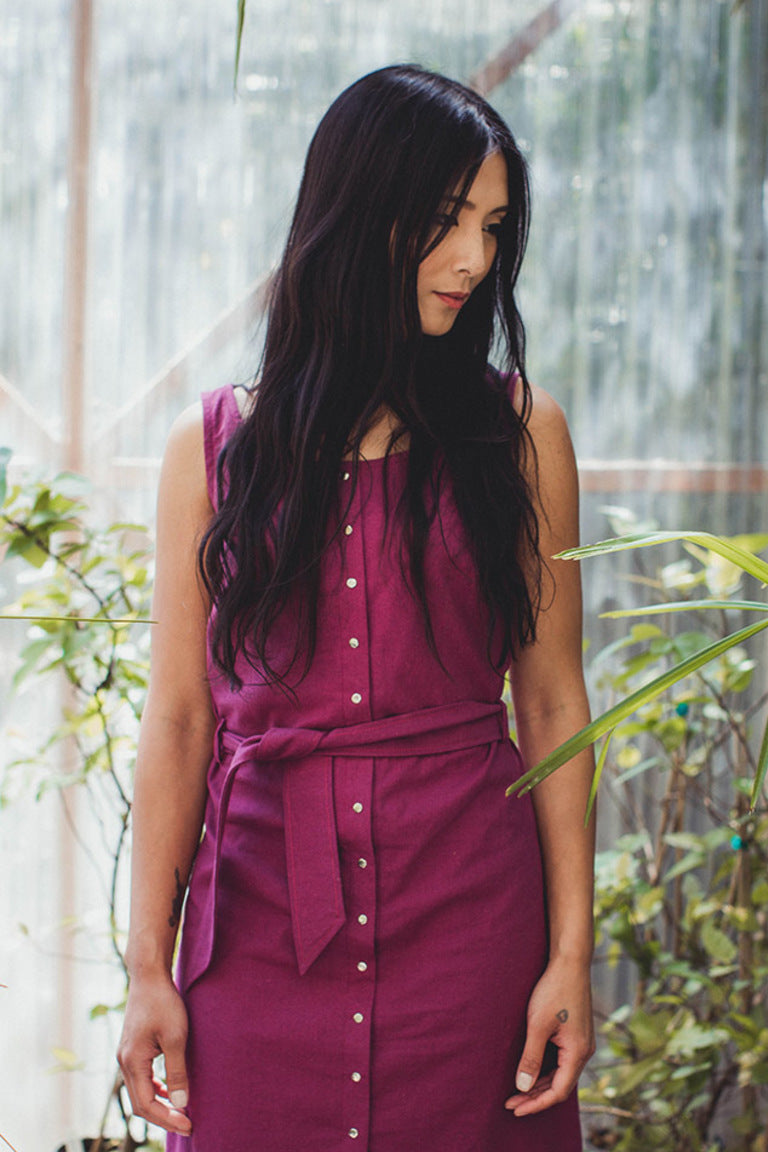Woman wearing a purple dress with a blurred green background