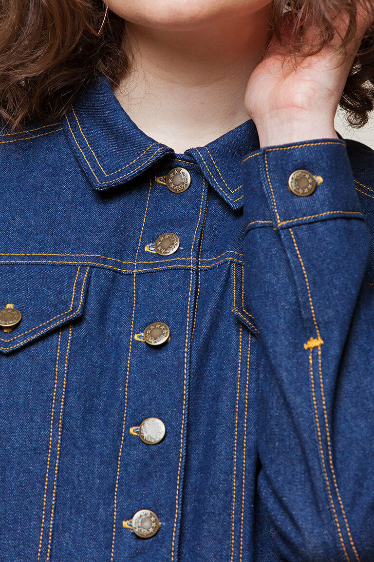 Close-up of a blue denim jacket with gold buttons