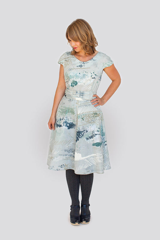 Woman wearing a light blue floral dress on a white background
