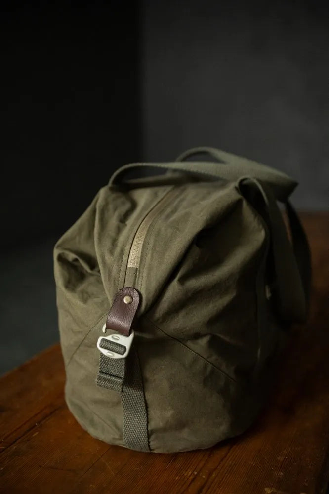 Green backpack on a wooden surface with a dark background