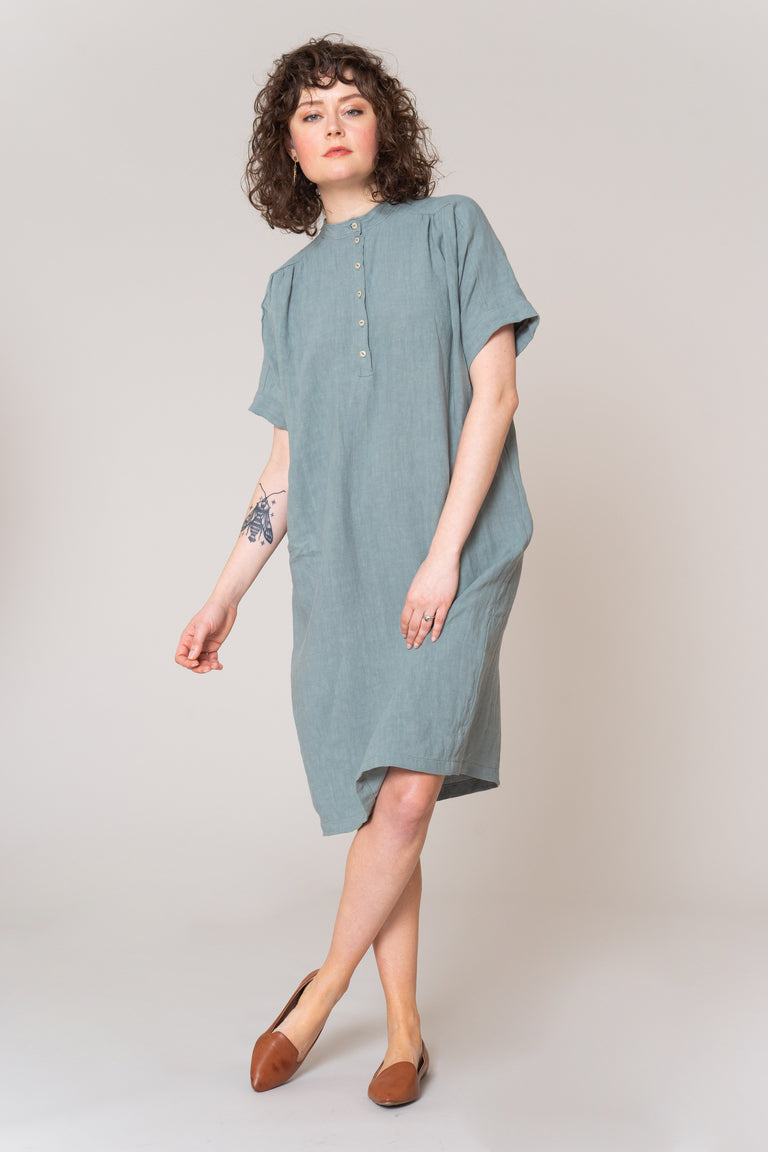 Woman wearing a light blue dress on a plain background
