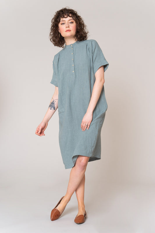 Woman wearing a light blue dress on a plain background