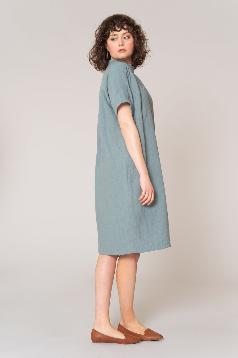 Woman wearing a light blue dress on a plain background