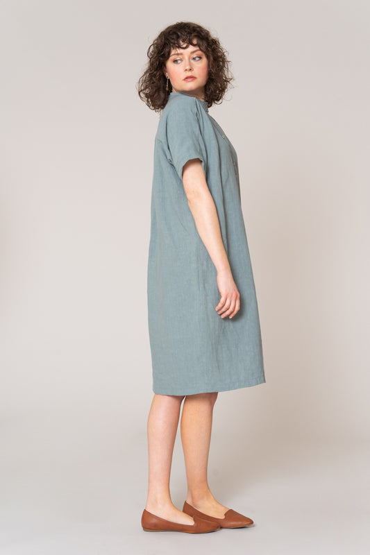 Woman wearing a light blue dress on a plain background