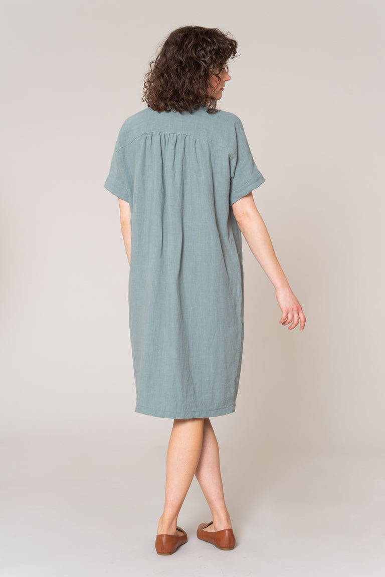 Woman wearing a light blue dress against a plain background