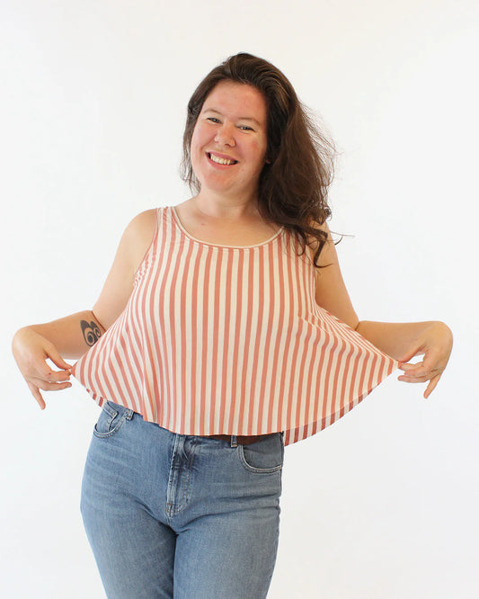 Woman wearing a red and white striped tank top and blue jeans on a white background