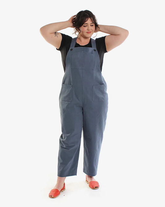 Woman wearing blue overalls on a white background