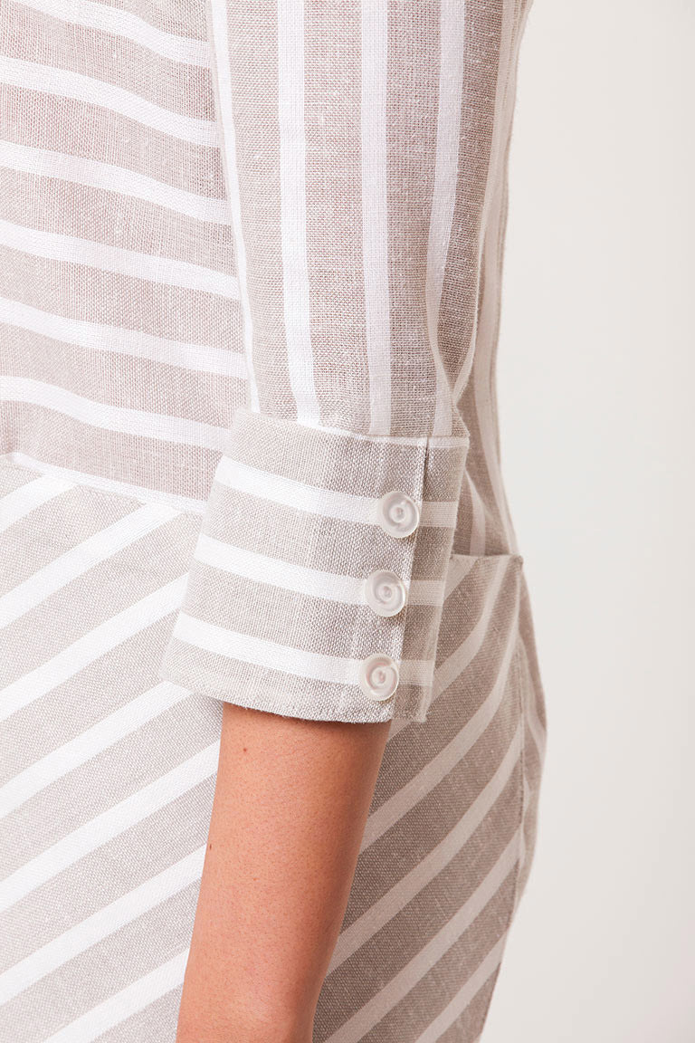 Close-up of a person wearing a striped shirt with a neutral background